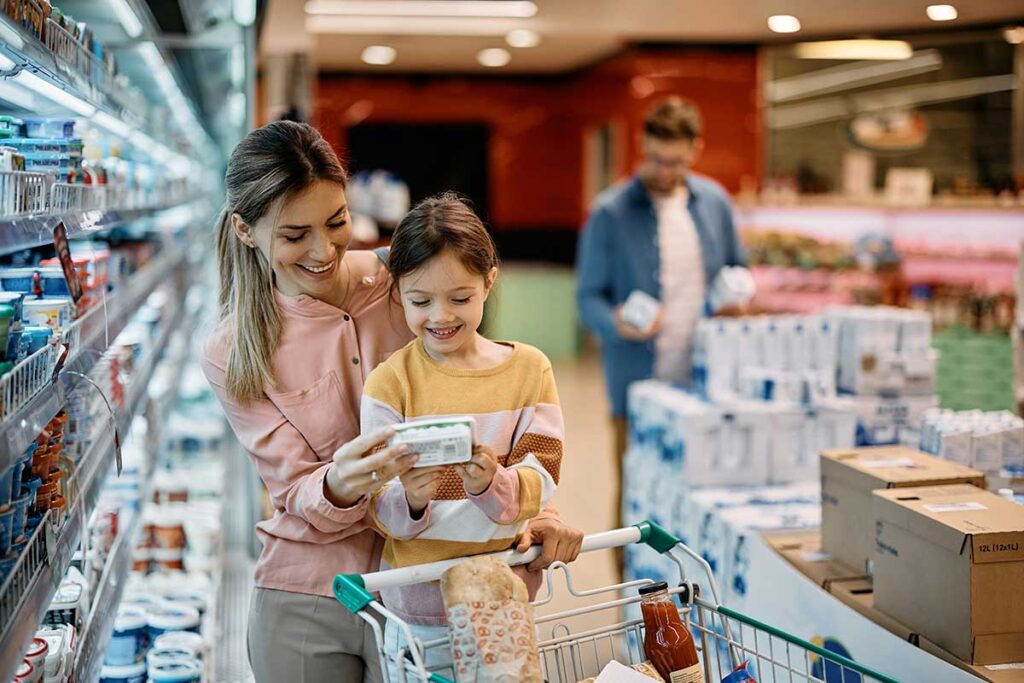Child-reading-food-label-grocery-store-parent